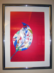 Framed painting of white leaf shape with many colored shapes inside set against a red background