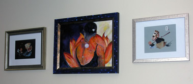 Photo of three framed mixed media works -- the largest middle piece features red floral image